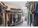 Organized walk-in closet with ample shelving, hanging racks, and a view of the backyard at 130 Emerald Dr, Mcdonough, GA 30253