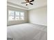 Spacious bedroom featuring soft carpet, a tray ceiling, and a large window at 3468 Jasmine Sw Way, South Fulton, GA 30331