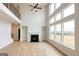 Spacious living room with wood-look floors, a cozy fireplace, large windows offering backyard views, and high ceilings at 3468 Jasmine Way Sw, South Fulton, GA 30331
