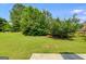 The backyard features lush, green grass and trees at 305 Overland Trl, Temple, GA 30179