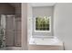 Bright bathroom featuring a large soaking tub and separate shower for relaxation at 305 Overland Trl, Temple, GA 30179