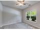 This carpeted bedroom has a ceiling fan, neutral walls, and a window at 305 Overland Trl, Temple, GA 30179