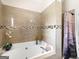 A large garden tub is surrounded by decorative tile and a glass shower enclosure at 8180 Chapman Ter, Mcdonough, GA 30252