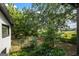 Lush backyard featuring mature trees and landscaping with distant views of a field and outbuildings at 98 Maddox Dr, Mcdonough, GA 30252