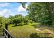 Manicured lawn with mature shrubs and trees with a dark stained fence in the foreground at 98 Maddox Dr, Mcdonough, GA 30252