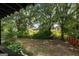 Tranquil backyard featuring mature trees and landscaping with distant views of a home and field at 98 Maddox Dr, Mcdonough, GA 30252