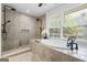 This bathroom features a soaking tub, stone tile, and sleek black fixtures at 98 Maddox Dr, Mcdonough, GA 30252