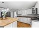 Kitchen with butcher block island, white cabinets, stainless appliances, and hardwood floors at 98 Maddox Dr, Mcdonough, GA 30252