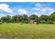 Expansive green field with a utility structure, cargo box and vehicle in the distance at 98 Maddox Dr, Mcdonough, GA 30252