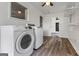 Clean laundry room equipped with a washer, dryer, shelving, and plank flooring at 98 Maddox Dr, Mcdonough, GA 30252