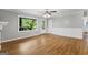 Bright living room with hardwood floors, wainscoting, ceiling fan, and a large window at 98 Maddox Dr, Mcdonough, GA 30252