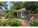 Charming blue and white outbuilding with ample glass under a pergola in a garden setting at 98 Maddox Dr, Mcdonough, GA 30252