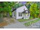 Charming two-story home with a front porch and well-maintained lawn surrounded by mature trees at 1174 Princess Sw Ave, Atlanta, GA 30310