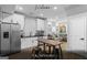 Renovated kitchen with stainless steel appliances, white cabinetry and a breakfast table, connecting to the living area at 1174 Princess Sw Ave, Atlanta, GA 30310