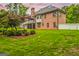 Spacious backyard with lush green grass and a charming brick house, framed by mature trees at 150 Old Plantation Way, Fayetteville, GA 30214