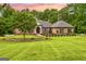 Stunning brick home with lush landscaping, mature trees, and a sprawling green lawn at 150 Old Plantation Way, Fayetteville, GA 30214