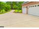 Exterior view of a two-car garage with a long driveway and landscaped front yard at 150 Old Plantation Way, Fayetteville, GA 30214