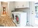 Well-lit laundry room with modern washer and dryer, custom cabinets, and tile flooring at 150 Old Plantation Way, Fayetteville, GA 30214