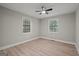 A sunlit bedroom featuring hardwood floors, ceiling fan, and two windows at 438 Punkintown Rd, Villa Rica, GA 30180