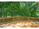 Wooden deck with railings surrounded by lush trees at 438 Punkintown Rd, Villa Rica, GA 30180