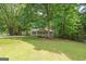 Home's front yard featuring mature trees, lush green lawn, and a charming home exterior at 438 Punkintown Rd, Villa Rica, GA 30180
