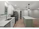 Stylish kitchen featuring stainless appliances, quartz counters, and a green island at 438 Punkintown Rd, Villa Rica, GA 30180