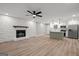 Spacious living area featuring a stone fireplace, ceiling fan, and modern kitchen at 438 Punkintown Rd, Villa Rica, GA 30180