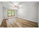 Comfortable bedroom featuring hardwood flooring, a ceiling fan, and a large window at 409 Deergrass Trl, Peachtree City, GA 30269