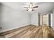 Spacious bedroom featuring wood-look floors, ceiling fan, and closet with modern doors at 409 Deergrass Trl, Peachtree City, GA 30269