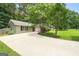 Spacious driveway leading to a well-maintained home surrounded by mature trees and lush landscaping at 409 Deergrass Trl, Peachtree City, GA 30269