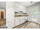 Functional kitchen featuring white cabinetry, granite counters, stainless appliances, and a door to the outside at 409 Deergrass Trl, Peachtree City, GA 30269