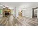 Open living area featuring hardwood flooring, a stone fireplace, and seamless flow to the kitchen at 409 Deergrass Trl, Peachtree City, GA 30269