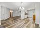 Spacious living space with hardwood flooring, adjacent dining area and kitchen, and bright lighting at 409 Deergrass Trl, Peachtree City, GA 30269