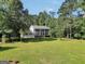 Charming two-story home featuring a spacious lawn and a classic colonial design with mature trees at 437 Mays Rd, Stockbridge, GA 30281