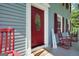 Inviting front porch features classic rocking chairs and a red door, creating a warm welcome at 437 Mays Rd, Stockbridge, GA 30281