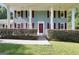 Inviting front porch with classic columns and well-manicured bushes, with a vibrant red front door at 437 Mays Rd, Stockbridge, GA 30281