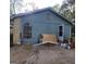 Side exterior of a home with light blue siding, brick, an arched window, and open side door at 2884 Haddon Dr, Rex, GA 30273