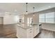Open-concept kitchen features a granite island, stainless steel appliances and a view into the living room with fireplace at 315 Westfall Ter # 226A, Loganville, GA 30052