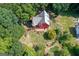 Aerial view of a beautiful home surrounded by lush trees, manicured yard, and a large deck at 3498 Overland Trl, Ellenwood, GA 30294