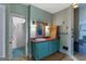 Colorful bathroom showcasing a teal vanity, tiled shower, and vintage decor at 3498 Overland Trl, Ellenwood, GA 30294