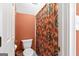 Standard bathroom with a toilet, shower featuring a patterned curtain, and built-in towel rack at 3498 Overland Trl, Ellenwood, GA 30294