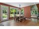 Bright breakfast nook with large windows overlooking lush greenery, wooden floors, and stylish lighting at 3498 Overland Trl, Ellenwood, GA 30294
