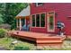 Exterior view of a deck with seating and a grill, complemented by lush landscaping and nearby trees at 3498 Overland Trl, Ellenwood, GA 30294