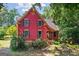 Inviting red two-story home with well-maintained lawn and classic architectural details at 3498 Overland Trl, Ellenwood, GA 30294
