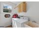Functional laundry room featuring a washer, dryer, storage cabinet, and utility sink at 3498 Overland Trl, Ellenwood, GA 30294