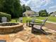 Backyard features fire pit on stone patio, lush green grass, and wooded view at 2643 Edgewater Ct, Jonesboro, GA 30236