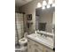 Bathroom features vanity, toilet and shower with stylish striped curtain at 2643 Edgewater Ct, Jonesboro, GA 30236