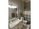 Bathroom features vanity, toilet and shower with stylish striped curtain at 2643 Edgewater Ct, Jonesboro, GA 30236