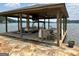 Covered boat dock with furniture, TV, and boat parking with stone landscape at 2643 Edgewater Ct, Jonesboro, GA 30236