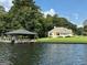 Exterior waterfront view of home with lake dock, manicured lawn, and waterfront at 2643 Edgewater Ct, Jonesboro, GA 30236